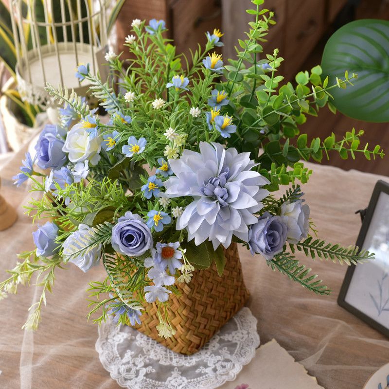 Kunstig blomsterdekoration i en flettet kurv
