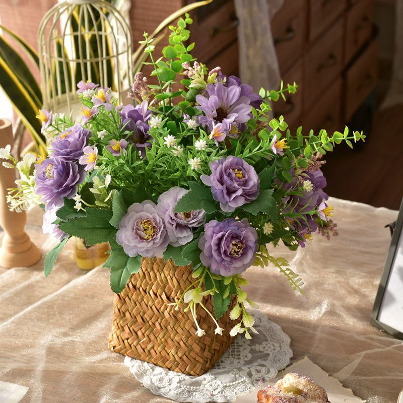 Kunstig blomsterdekoration i en flettet kurv