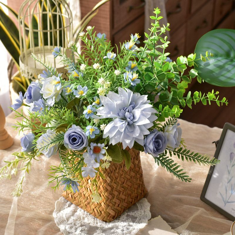 Kunstig blomsterdekoration i en flettet kurv